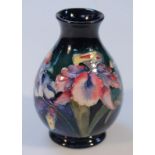 A 20thC Moorcroft Orchid pattern vase, the circular bellied body with a blue ground on circular