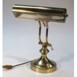 A 20thC Art Deco design brass table lamp, with shaped shade on cylindrical supports terminating in a