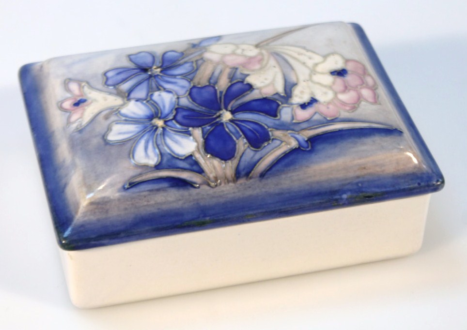 A Moorcroft salt glaze Spring Flowers pattern box and cover, on a blue ground impressed marks and