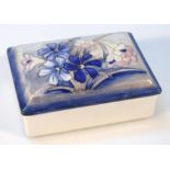 A Moorcroft salt glaze Spring Flowers pattern box and cover, on a blue ground impressed marks and