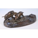 A 20thC patinated bronze ink stand, composed of two boars play fighting before a hinged opening on a