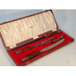 A 20thC cased Harrods carving set, each with orb pommels and collars and horn finish handles, with