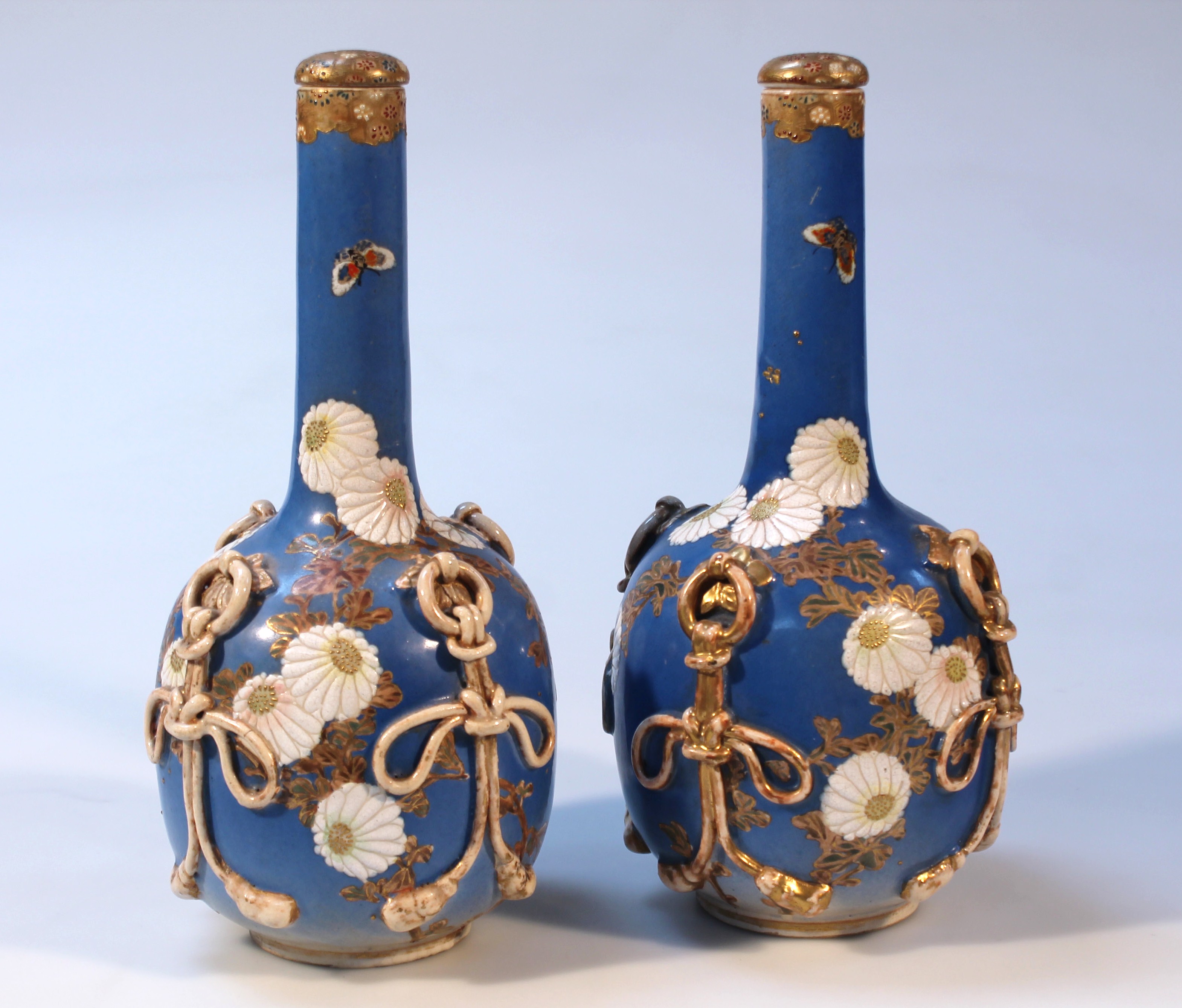 A pair of 20thC Japanese earthenware bottle vases and stoppers, each bulbous body raised with an