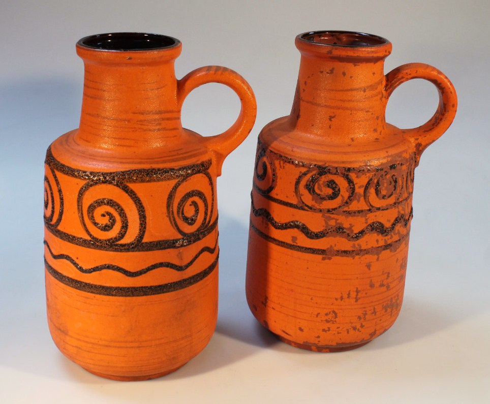 A pair of 1960's West German earthenware ewers, each circular body in orange with geometric