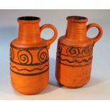 A pair of 1960's West German earthenware ewers, each circular body in orange with geometric