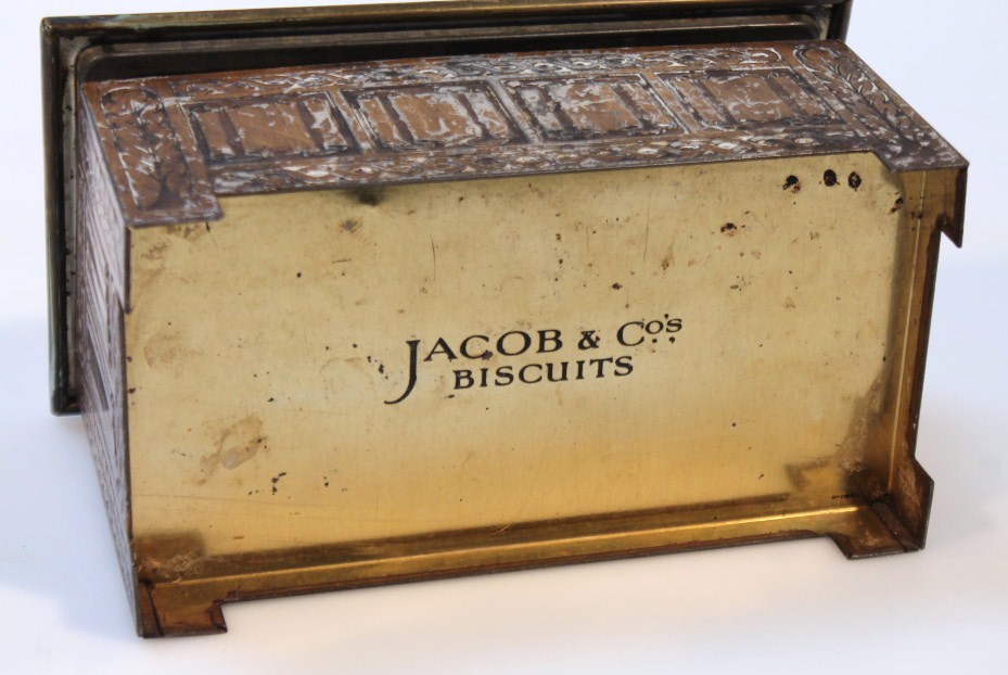 An early 20thC Jacob & Co. biscuit tin, in the form of a slipper box, the brass lid raised with - Image 3 of 3