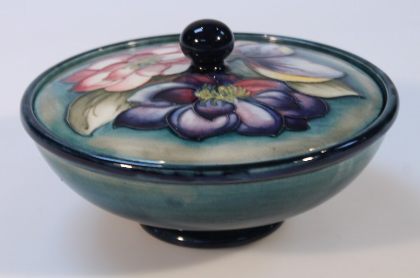 A mid-20thC Moorcroft Clematis pattern powder bowl and cover, on green ground, blue highlighted