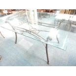 A glass topped dining table, with cast iron base with flared legs, 170cm wide.