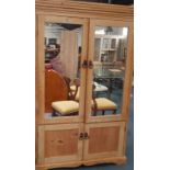 A Victorian pine fitted wardrobe, with mirrored doors, having top with interior clothes rail,