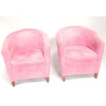 A pair of fuchsia suede effect tub chairs.