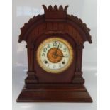 An Ansonia American Tunis 8 day oak mantel clock, having split chapter ring with Arabic numerals,