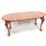 An oval mahogany extending dining table, with piecrust edge upon ball and claw feet, total width