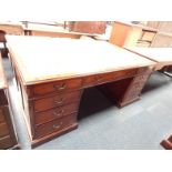 A Georgian style mahogany pedestal desk, having three frieze drawers comprising two short and one