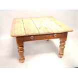 A pine short kitchen table, on turned legs with drawer, 110cms wide.