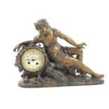 An early 20thC Continental reclining spelter figural mantel clock, the dial having floriate