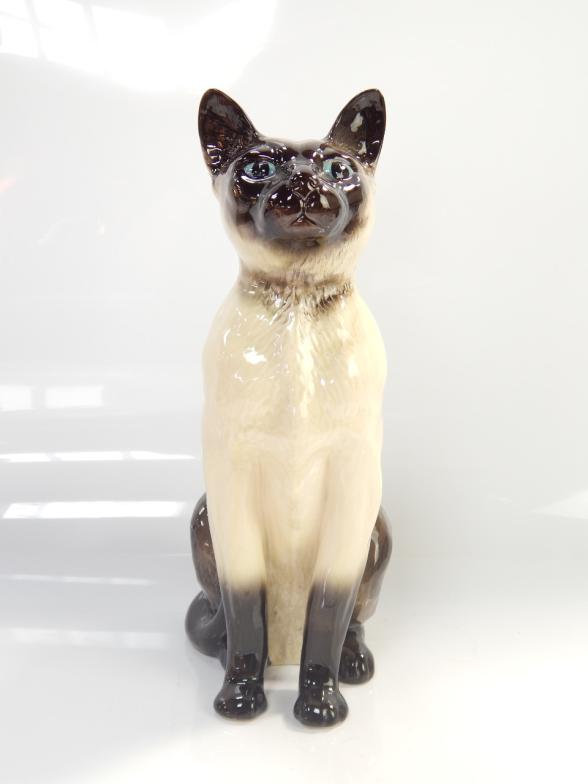 A Beswick Siamese cat, in seated position, 34cm high.