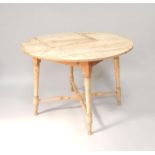 A Victorian circular stripped pine kitchen table, upon four legs with cross stretcher, 105cm.