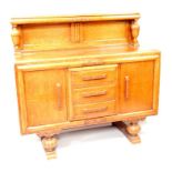 A 1930s oak sideboard, having galleried back with urn shaped supports above three short central