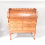 A mahogany roll top desk, having brass inlaid central cartouche to tambour, with extending desk