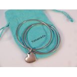 A Tiffany & Co triple bangle, with heart centre, marked 925, 7cm dia. 23.4g, complete with bag and