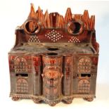 A 19thC treacle glazed pottery watch stand model of a house, in the manner of Oldfield, with an