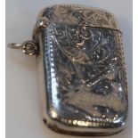 An Edwardian silver vesta case, by Samuel Levi the shaped rectangular body decorated with scrolls