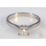 A ladies diamond solitaire ring, with a square cut claw set stone on a plain shank, platinum