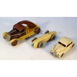 An early 20thC tinplate racing car, with metal wheels, marked Made in England, painted in cream