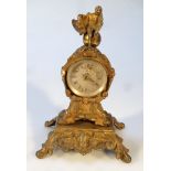 A 19thC rococo design travel clock, the gilt metal case surmounted by a figure in reflective mood,