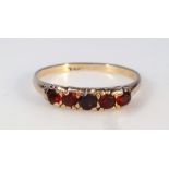 A ladies' garnet five stone dress ring, on unmarked yellow metal shank, size M, 1.7g.