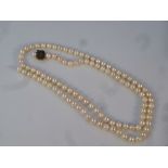 A cultured pearl necklace, on plain string, the clasp marked silver, 68g all in, 89cm long.