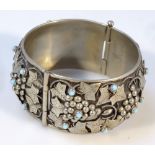 An Italian Art Nouveau design bangle, the circular body raised with various leaves and berries and