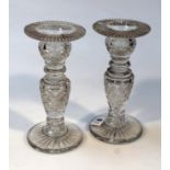 A pair of 19thC cut glass candlesticks, with wide rims with hobnail baluster stems on circular