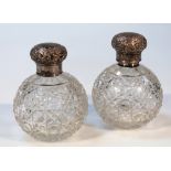 A pair of early 20thC cut glass and silver dressing table jars, each with hobnail cut bulbous bodies