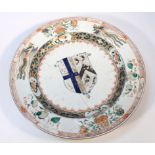 An early 18thC Chinese export porcelain armorial charger, with a circular outline centred by a