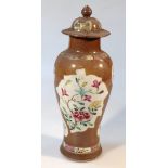 A porcelain vase, with domed overhanging lid, the shouldered body with a brown ground decorated with