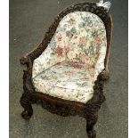 An Anglo Indian carved hardwood bergere chair, with acorn and oak leaf framing with Bacchanalian and