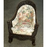 An Anglo Indian carved hardwood bergere chair, carved with oak leaves, acorns, egg and dart moulding