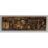 A heavily carved hardwood oriental panel, set with various figures to include a bearded sage with