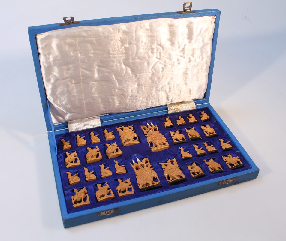 An Indian sandalwood chess set, the pieces carved as figures on the backs of elephants, camels and