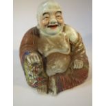 A Chinese porcelain figure, of a seated Buddha scantly clad and polychrome decorated in floral dress