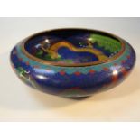 A 20thC Chinese cloisonne bowl, decorated with dragon and flowers on a blue gilt highlighted ground,