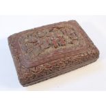 A heavily carved Chinese red sandalwood casket, the shaped rounded top centred with a panel carved