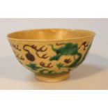 A Chinese porcelain yellow and green ground bowl, decorated with dragons and foliage on a circular