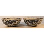 A pair of Chinese blue and white porcelain bowls, each circular outline centred with dragons with an