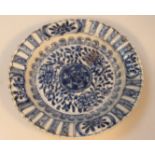 A Chinese porcelain blue and white saucer, the floral centre with a shaped outline with geometric