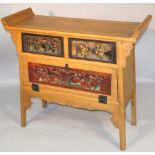 A 20thC oriental design hardwood side cabinet, with scroll ends, fronted by two heavily carved