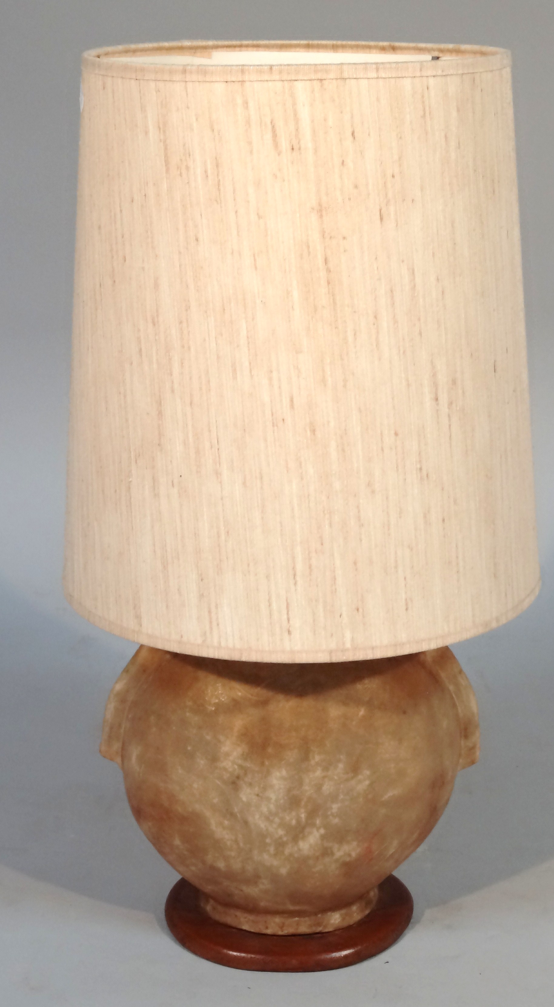 A 20thC lamp, the base possibly a bladder with wooden mounts and herringbone shaped shade, 64cm