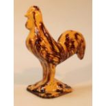 An early 19thC Staffordshire pottery tortoiseshell glazed figure of a cockerel, in a standing pose