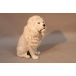 A 20thC Continental earthenware figure of a seated lion, realistically modelled in white with